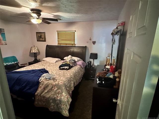 carpeted bedroom featuring a textured ceiling and ceiling fan