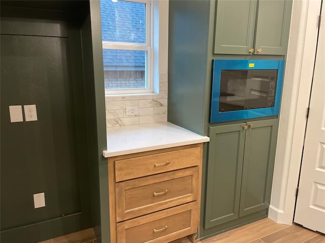 interior space featuring wood finished floors, backsplash, and built in microwave