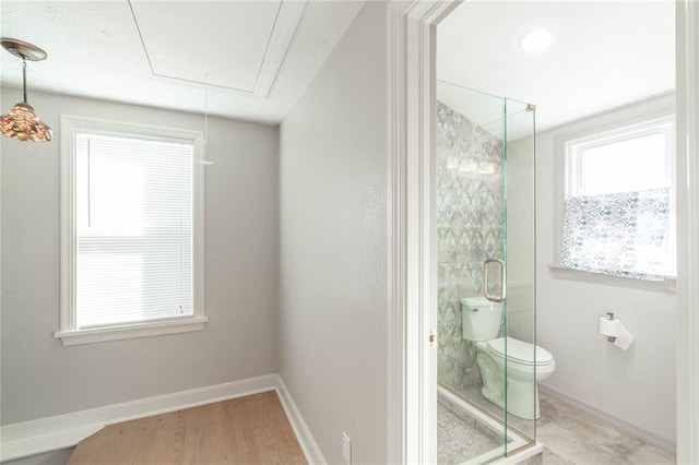 bathroom featuring toilet, a shower with shower door, and hardwood / wood-style floors