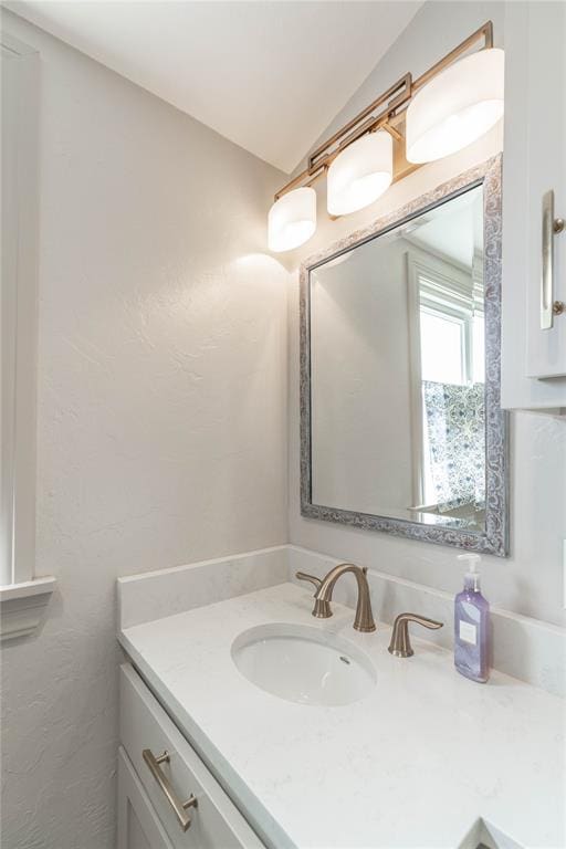 bathroom with vanity and vaulted ceiling