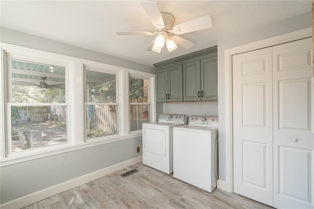 laundry area featuring ceiling fan, light hardwood / wood-style floors, washing machine and dryer, plenty of natural light, and cabinets