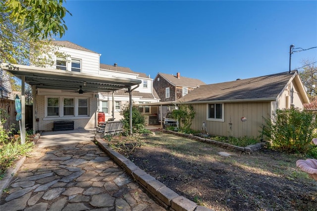 rear view of property with ceiling fan and a porch