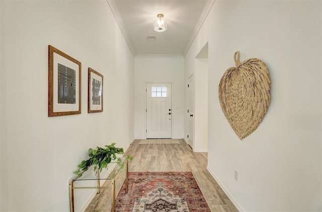 doorway to outside featuring light wood-type flooring and ornamental molding