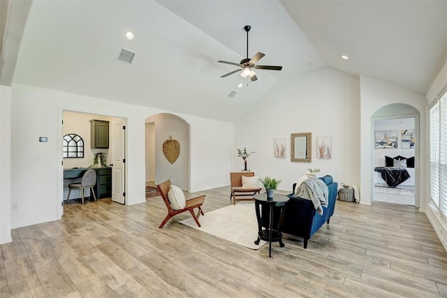 living room with light hardwood / wood-style floors, high vaulted ceiling, plenty of natural light, and ceiling fan