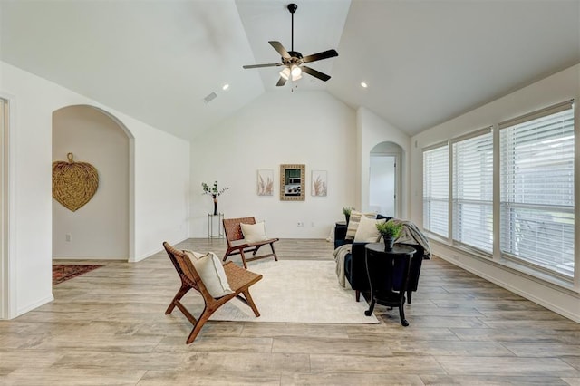 living room with light wood-type flooring, ceiling fan, and lofted ceiling