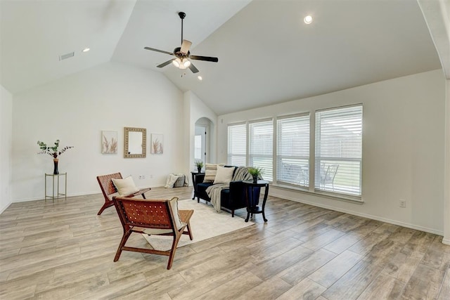 living room featuring ceiling fan, high vaulted ceiling, and light hardwood / wood-style flooring