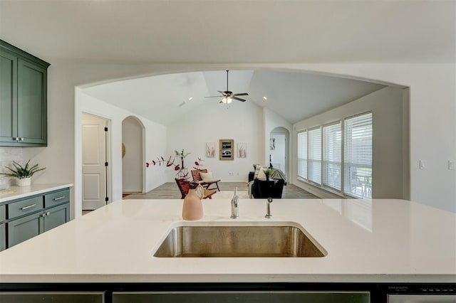 kitchen featuring vaulted ceiling, ceiling fan, sink, a center island with sink, and green cabinetry