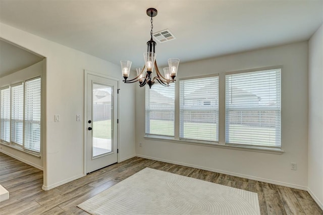 interior space featuring a notable chandelier, light hardwood / wood-style floors, and a wealth of natural light