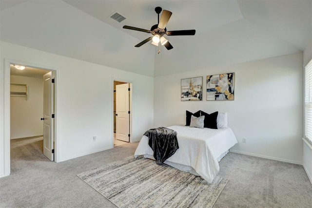 bedroom with multiple windows, a spacious closet, vaulted ceiling, and ceiling fan