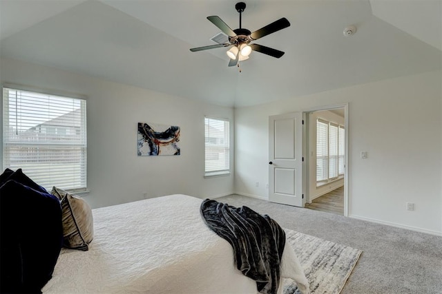 bedroom featuring light colored carpet, multiple windows, lofted ceiling, and ceiling fan