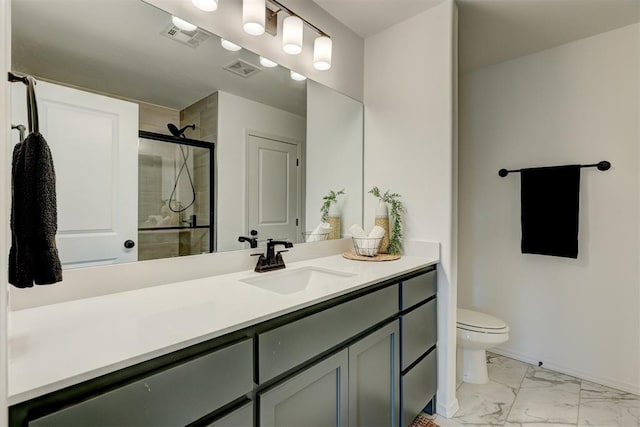 bathroom featuring vanity, a shower with shower door, and toilet