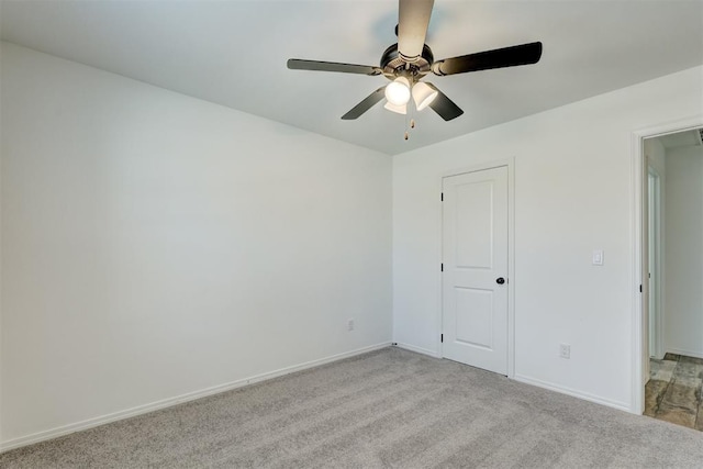 carpeted spare room with ceiling fan