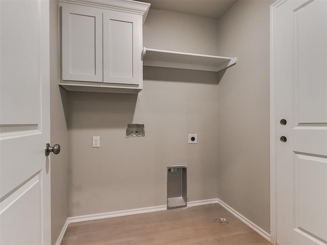 washroom featuring cabinet space, baseboards, light wood-style floors, washer hookup, and electric dryer hookup