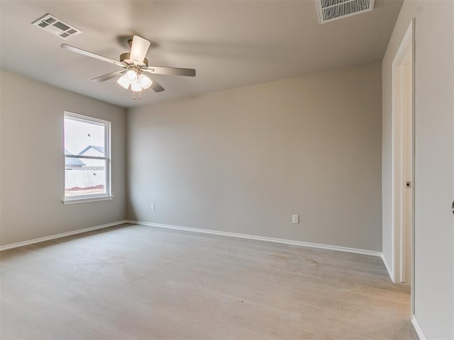 spare room featuring baseboards, visible vents, and ceiling fan