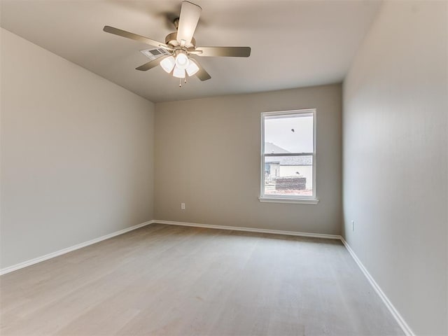 spare room featuring light wood-style floors, baseboards, and a ceiling fan