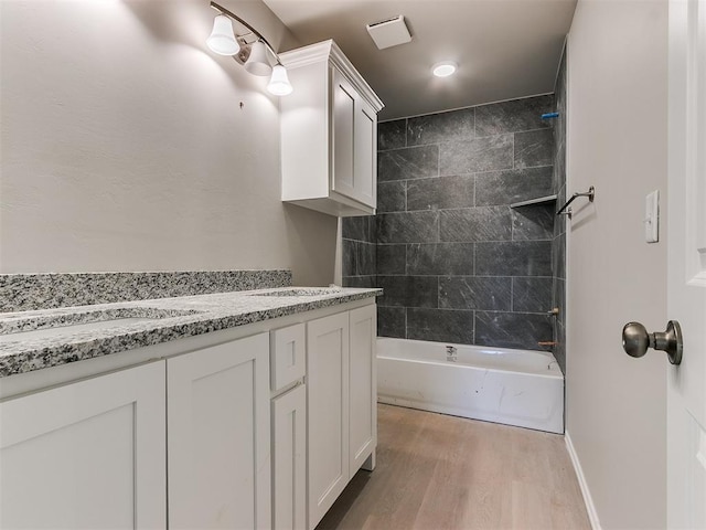 full bath featuring shower / washtub combination, vanity, baseboards, and wood finished floors