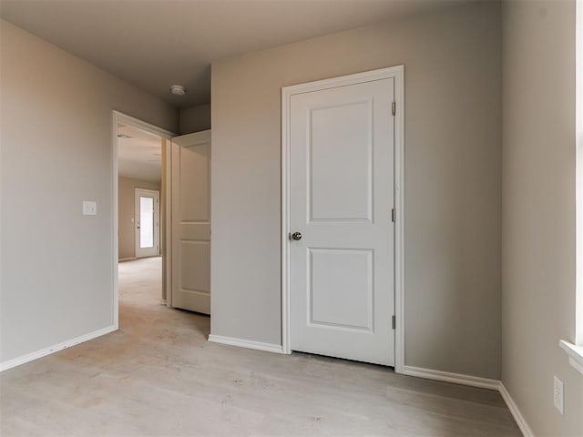 unfurnished bedroom featuring light wood-style floors and baseboards