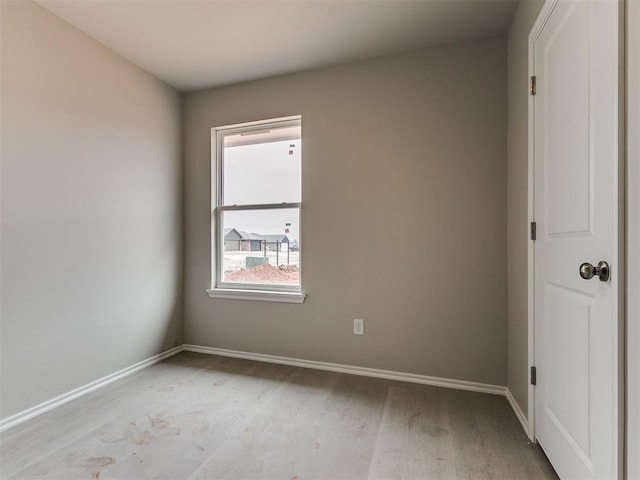 spare room with light wood-style flooring and baseboards