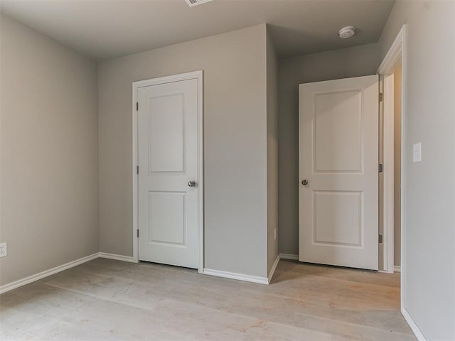 unfurnished bedroom with light wood finished floors and baseboards