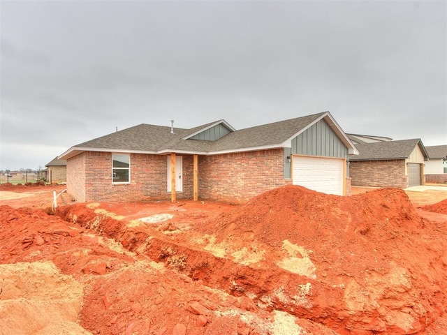 ranch-style home with an attached garage, brick siding, board and batten siding, and a shingled roof