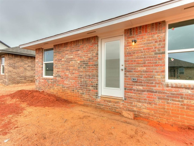 entrance to property featuring brick siding