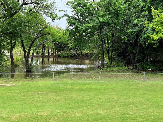 view of yard with a water view and fence