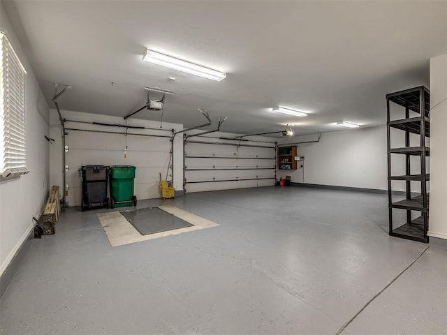 garage with baseboards and a garage door opener