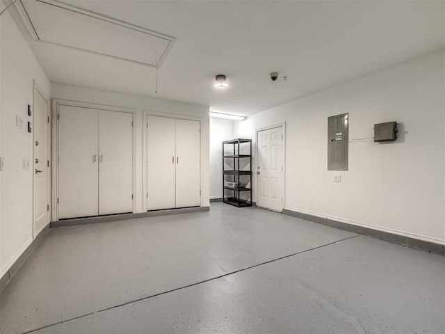 garage featuring electric panel and baseboards