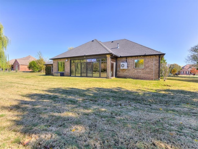 back of property featuring a yard, brick siding, and a shingled roof