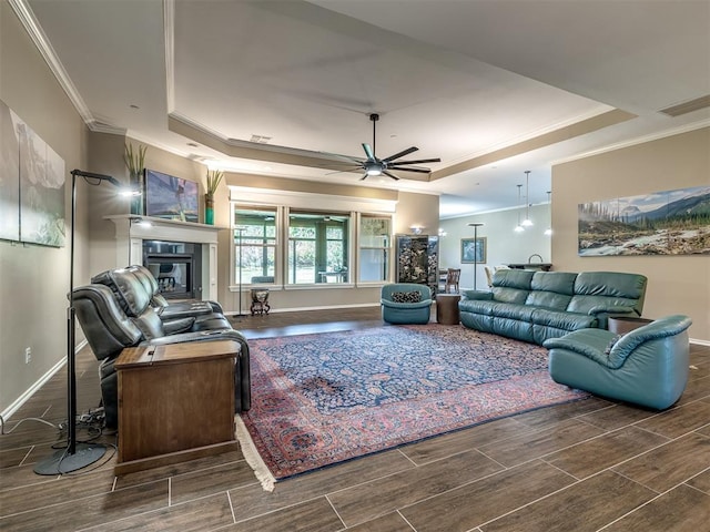 living room featuring wood tiled floor, a raised ceiling, and crown molding