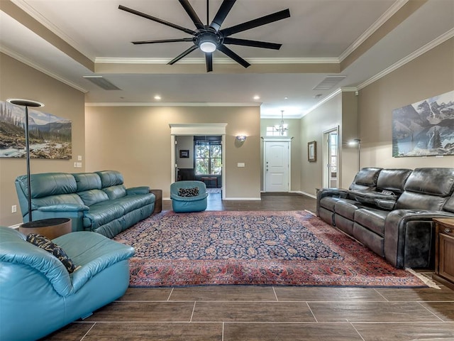 living room featuring a raised ceiling, visible vents, an inviting chandelier, ornamental molding, and baseboards