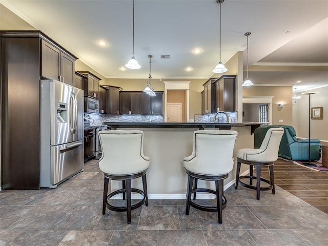 kitchen featuring tasteful backsplash, visible vents, appliances with stainless steel finishes, a breakfast bar, and dark brown cabinets