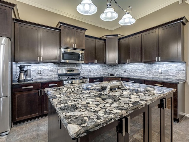 kitchen with tasteful backsplash, appliances with stainless steel finishes, dark stone countertops, dark brown cabinets, and crown molding