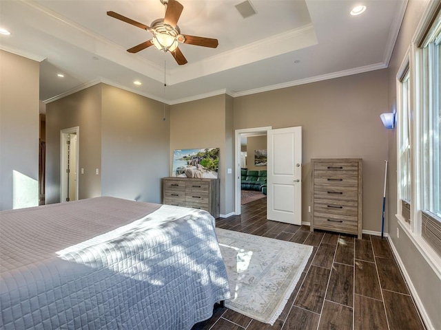 bedroom with wood tiled floor, a raised ceiling, crown molding, and baseboards