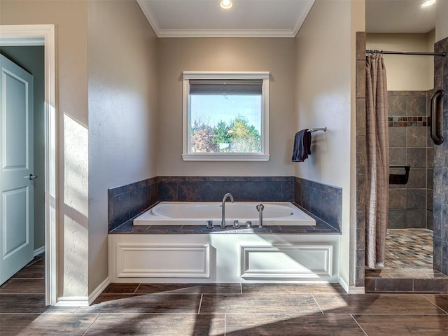 bathroom featuring a garden tub, ornamental molding, a tile shower, and wood finish floors