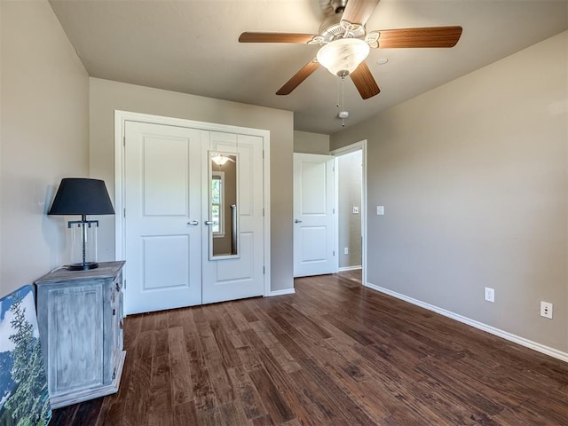 unfurnished bedroom featuring dark wood finished floors, a ceiling fan, and baseboards