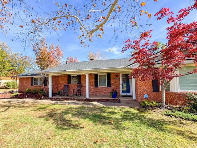 ranch-style home with a front yard and covered porch