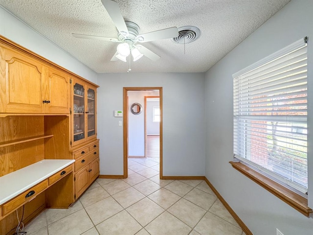 kitchen with ceiling fan, light tile patterned flooring, and a textured ceiling