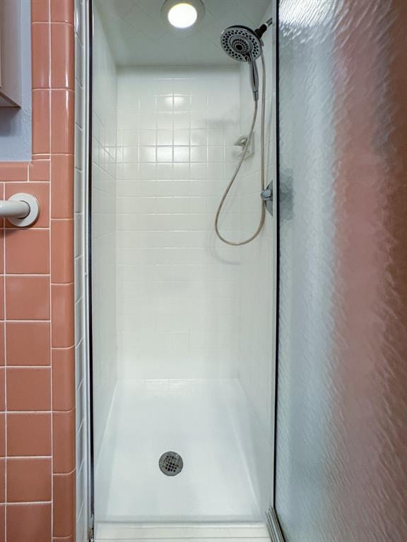 bathroom with a shower with door