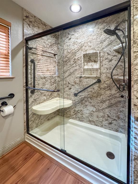 bathroom featuring wood-type flooring and a shower with door