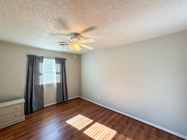 unfurnished room featuring a textured ceiling, ceiling fan, and dark hardwood / wood-style floors