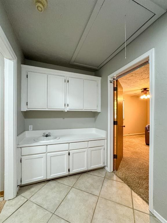 interior space featuring white cabinetry, sink, and light colored carpet