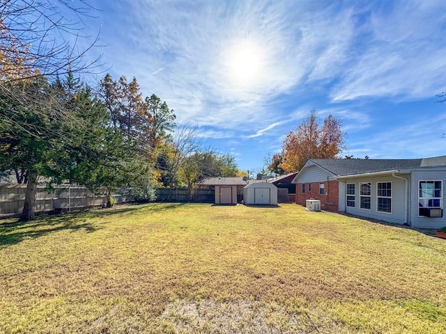 view of yard with central AC and a shed