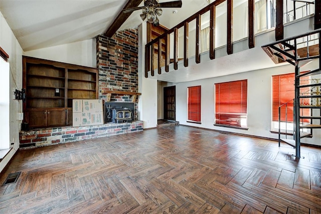 unfurnished living room featuring parquet floors, a wood stove, high vaulted ceiling, and ceiling fan