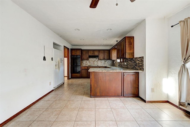 kitchen with ceiling fan, white fridge with ice dispenser, tasteful backsplash, double oven, and kitchen peninsula