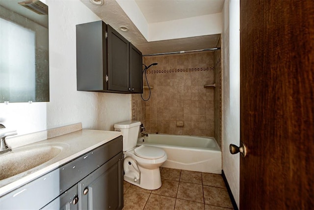 full bathroom with tile patterned floors, vanity, tiled shower / bath combo, and toilet