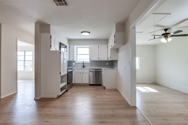 kitchen with white cabinetry, appliances with stainless steel finishes, light hardwood / wood-style floors, and sink