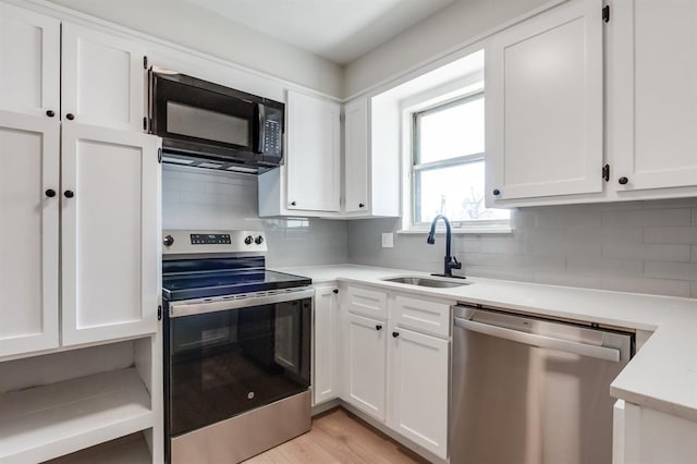 kitchen with tasteful backsplash, stainless steel appliances, sink, and white cabinets