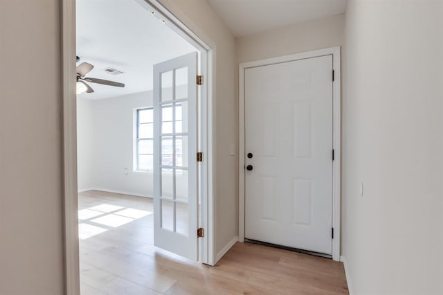 doorway to outside featuring ceiling fan and light wood-type flooring