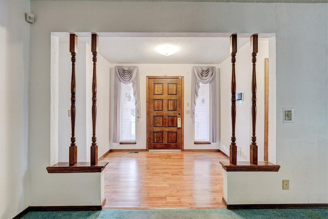 entryway featuring a textured ceiling and light hardwood / wood-style flooring